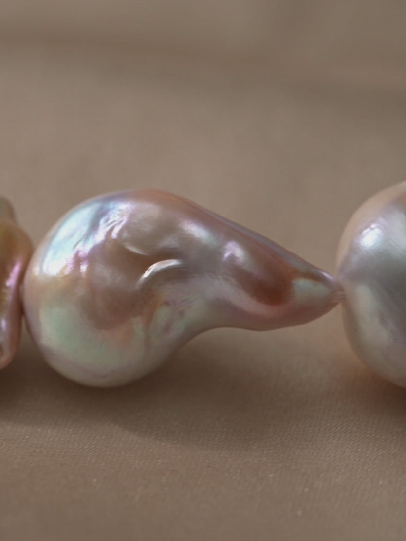 Anna Borjigin baroque pearl strand necklace detail showcasing lustrous, organically shaped peach and cream pearls.